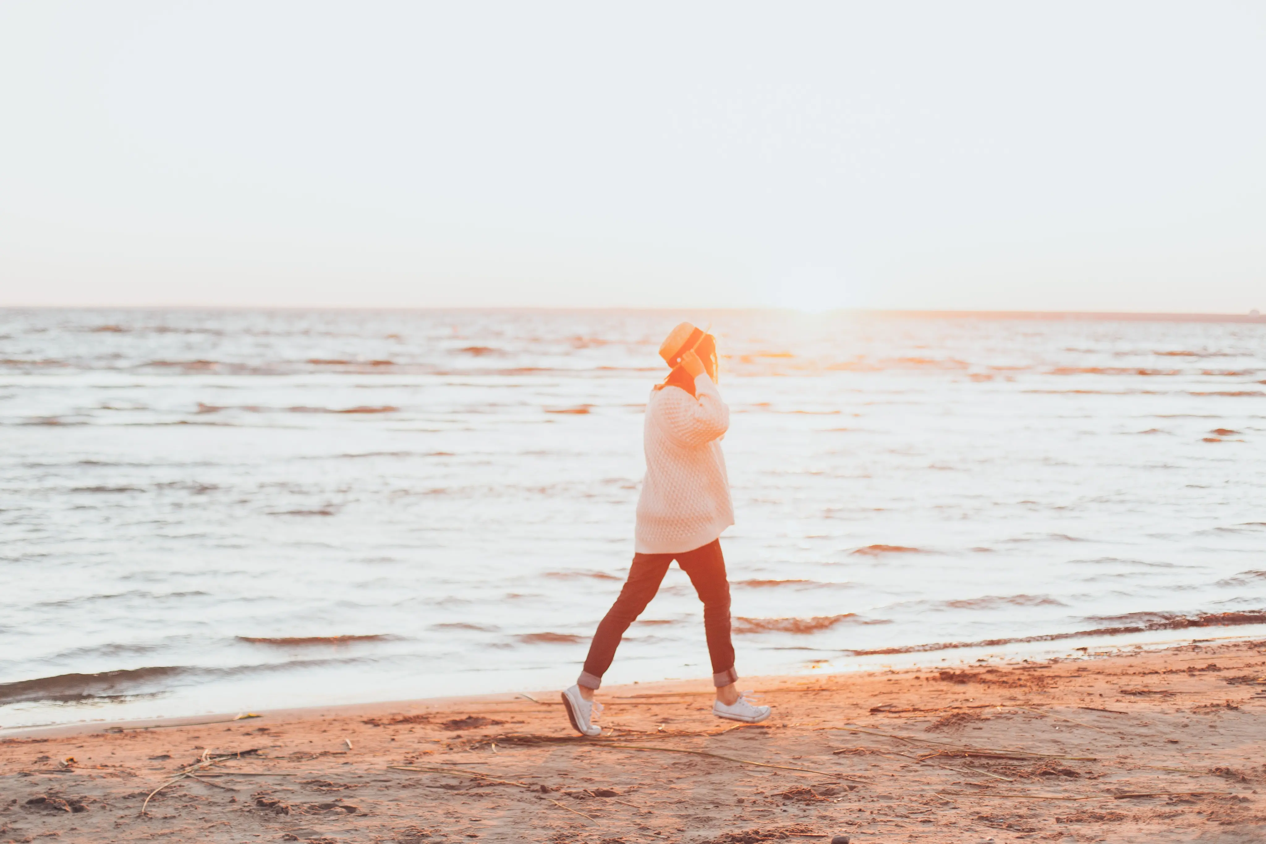 Woman walking on the beach at sunrise after bioidentical hormone therapy in Charleston