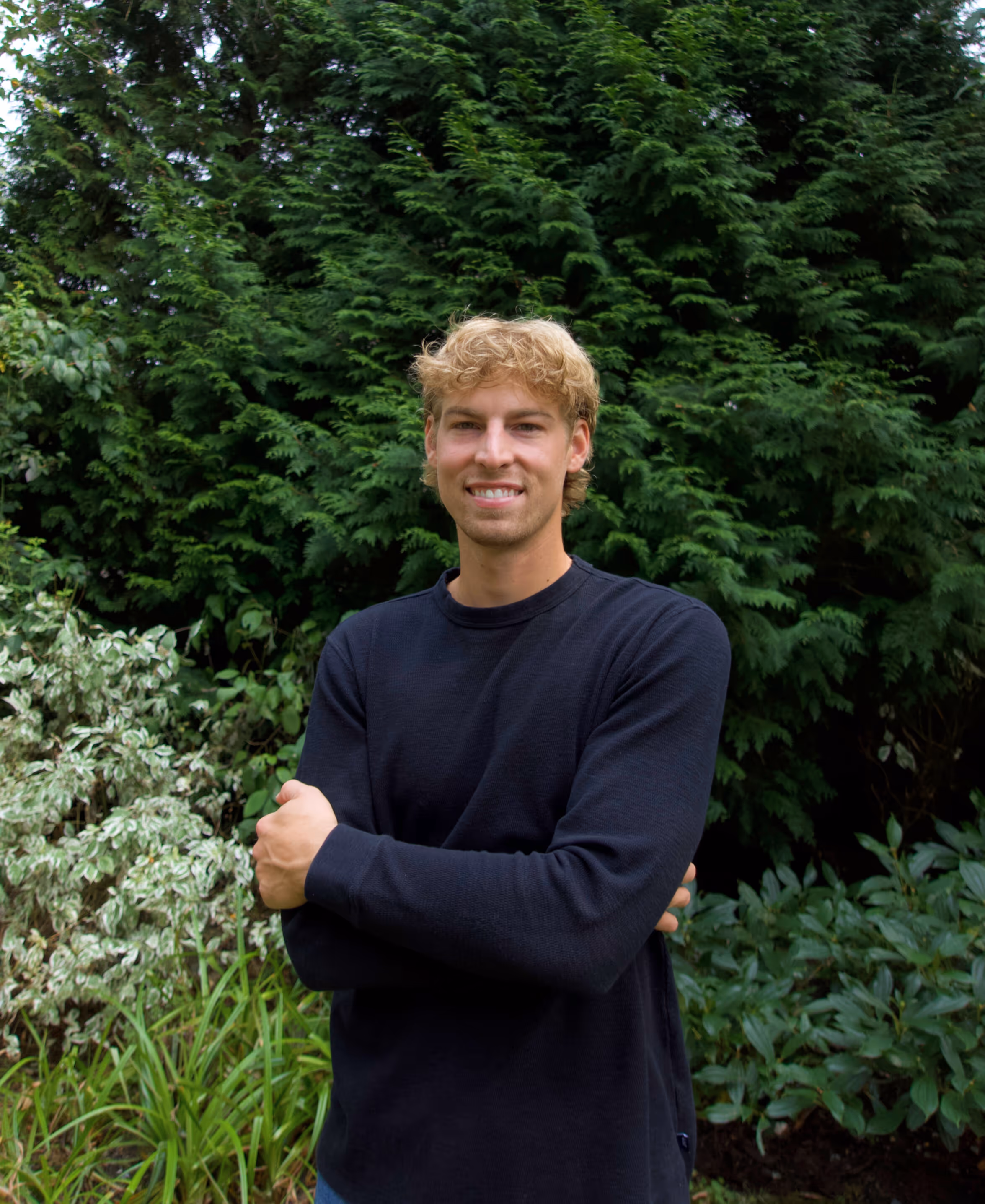 A portrait of Brody in front of a greenbelt background.