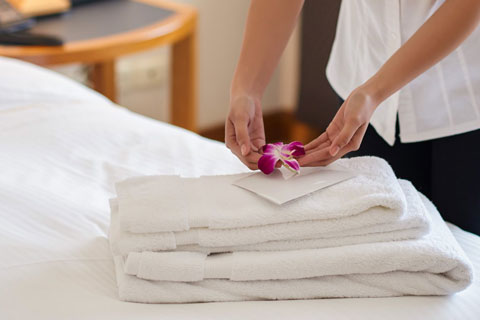 Maid Hands arranging towells and decorating with a flower