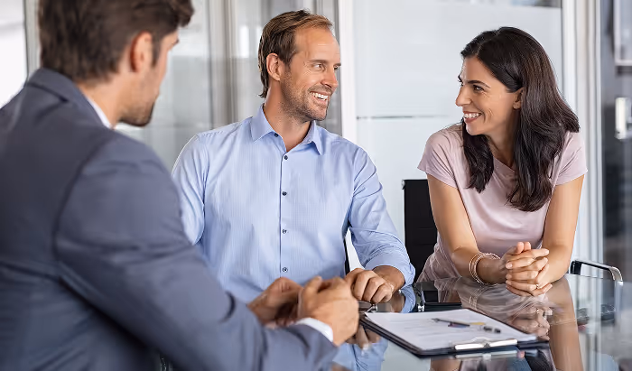 Business people at a table smiling.