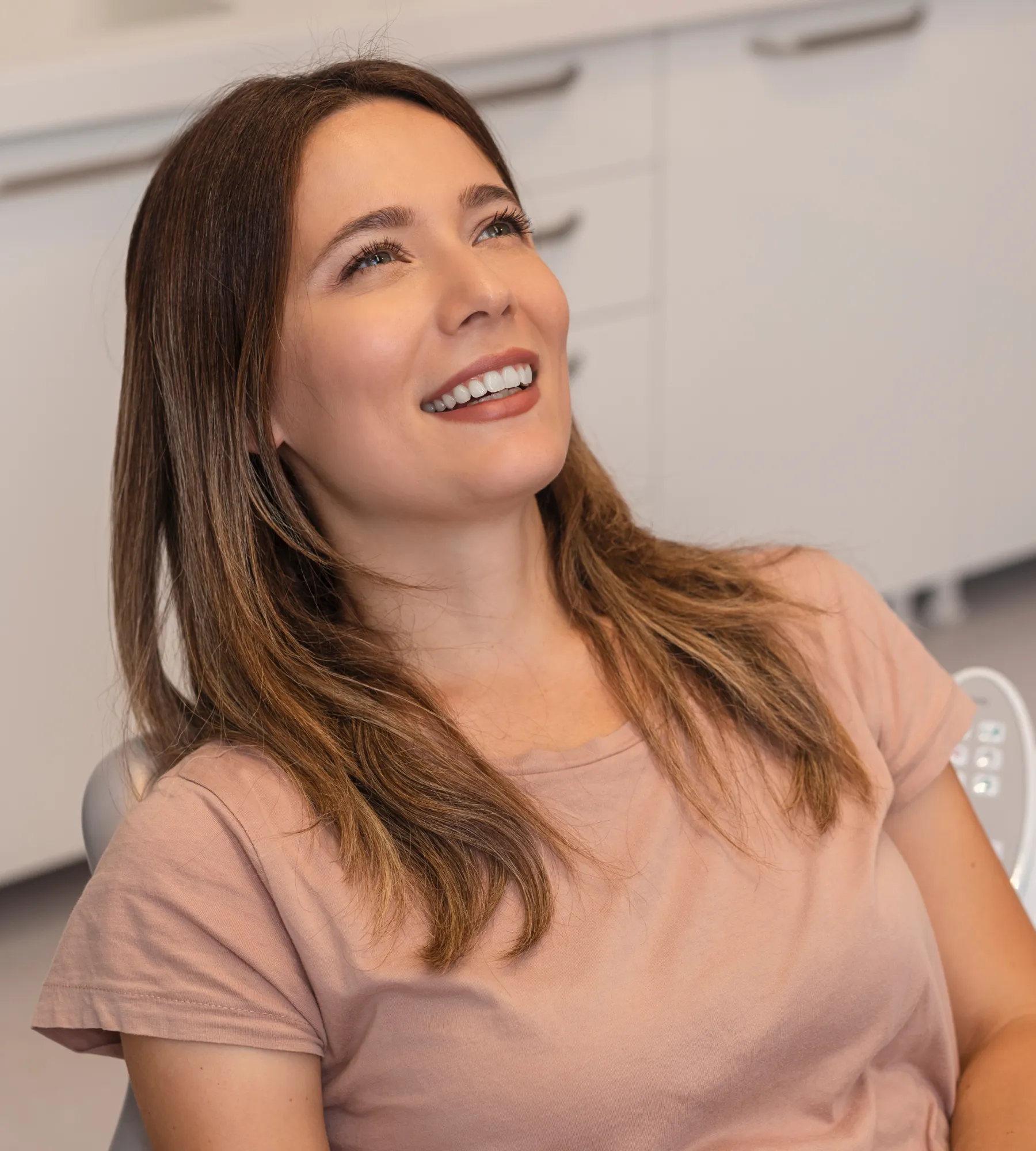 A woman at a reception desk hands paperwork to another woman holding forms.