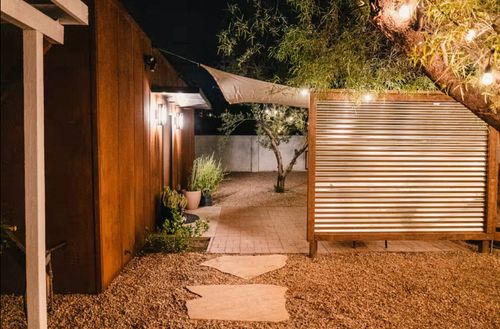 StayReady Tucson modern short term rental with desert landscape yard, privacy panel, and garden lighting