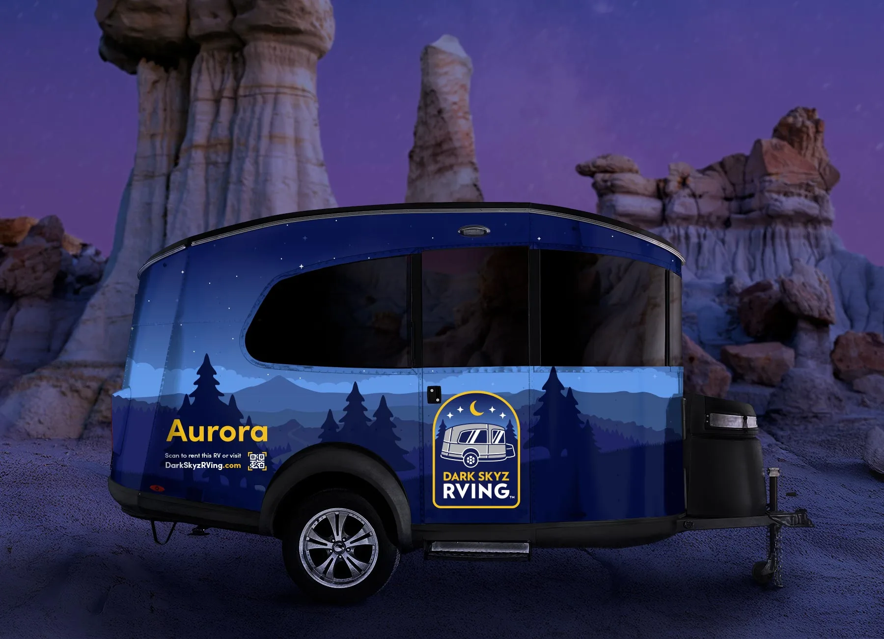 An Airstrem rv trailer parked at a camp site in the mountains with a camp fire next to it. The RV is vinyl wrapped with new branding for Dark Skyz RVing