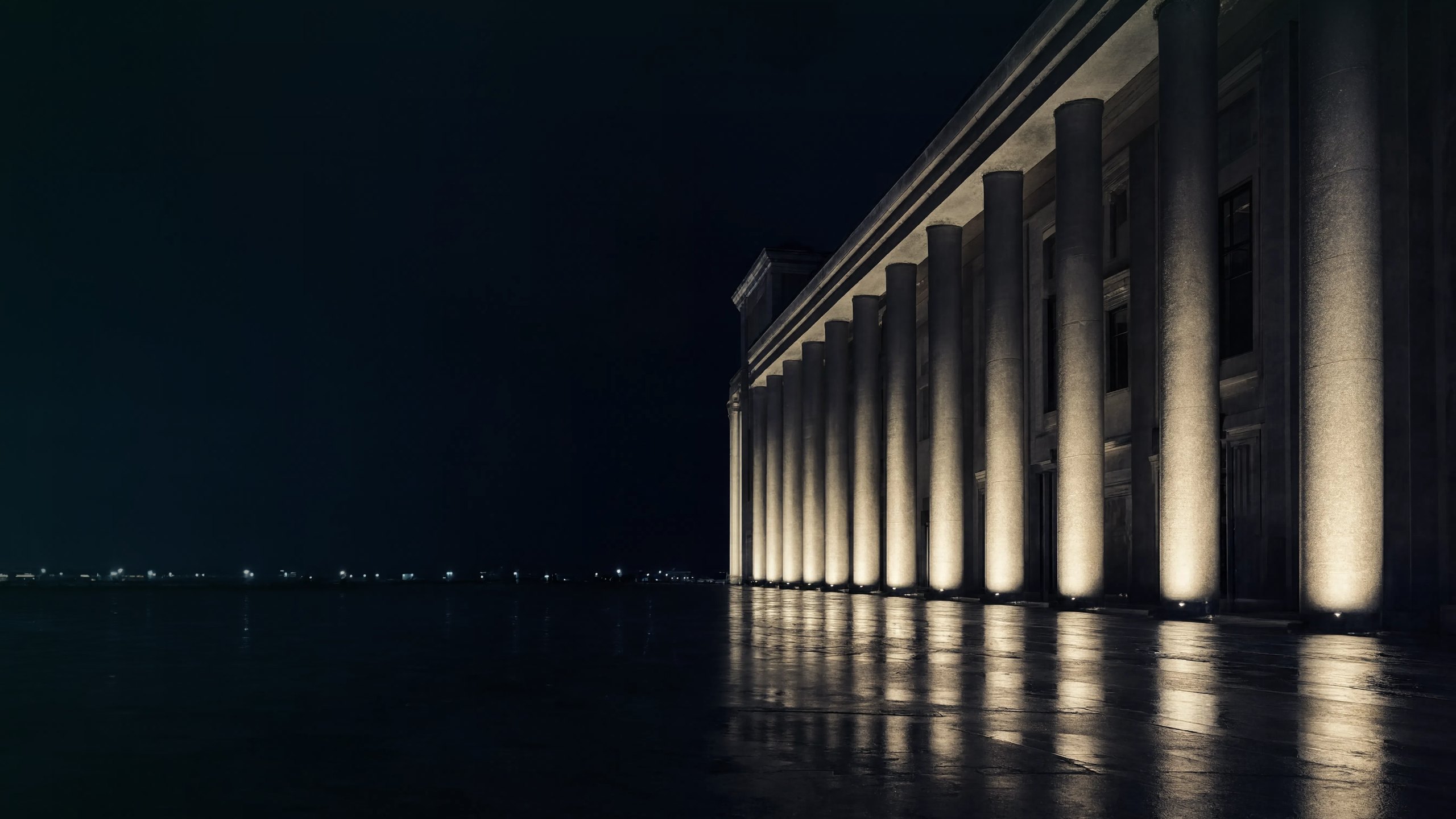 Arquitetura institucional à noite com colunata iluminada, compliance regulatório de carbono