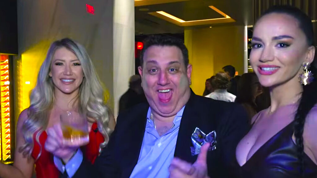 A man standing between two women at BetBash smiles