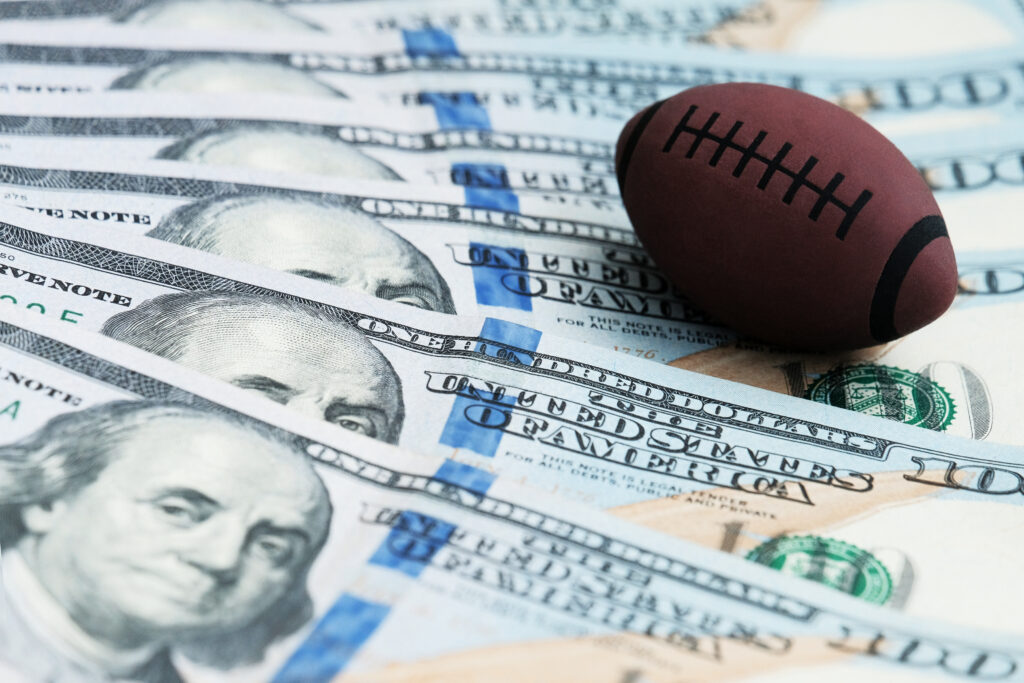 Football on a pile of $100 bills