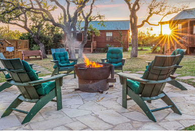 Cabin rentals in Austin with fire pit and outdoor seating area at sunset