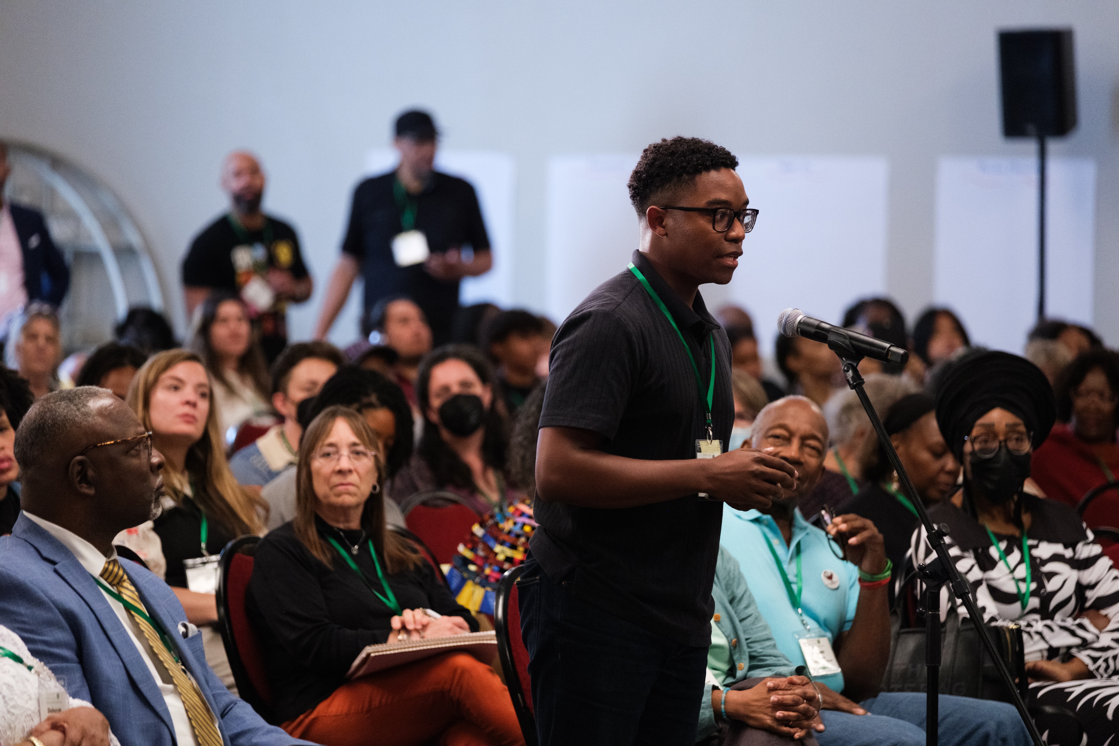 Young person standing and speaking at a convening