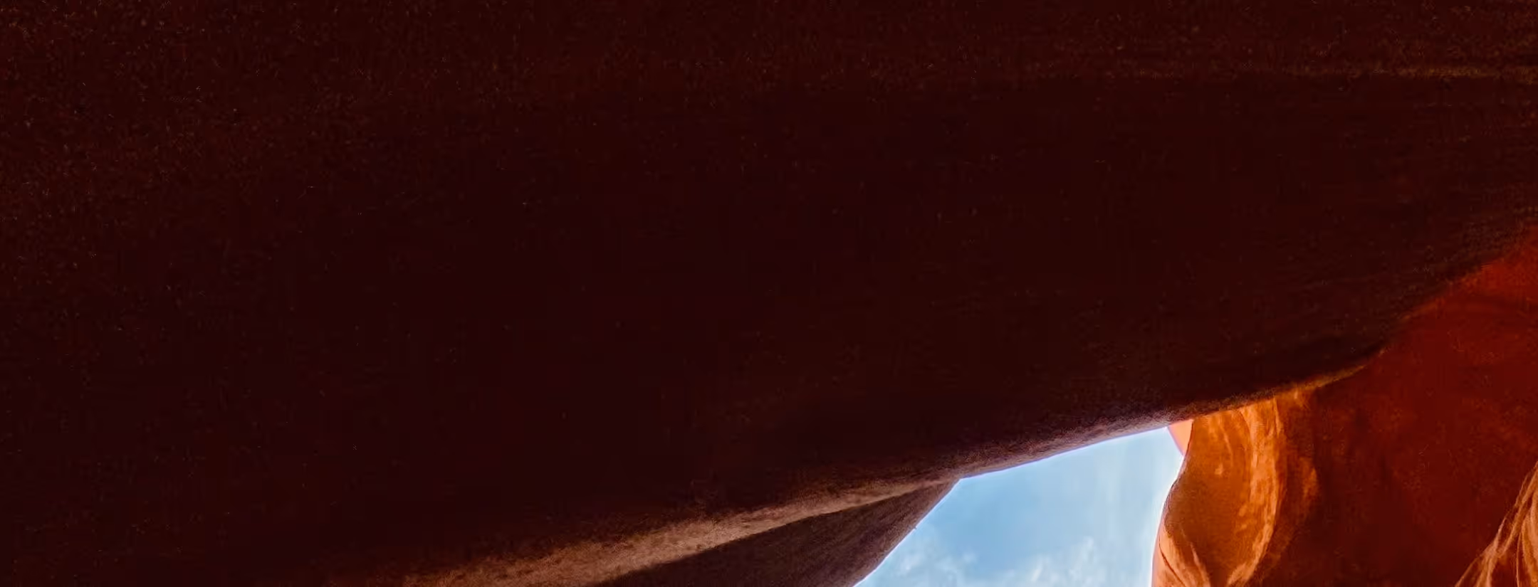 View from inside a sandstone canyon opening to blue sky