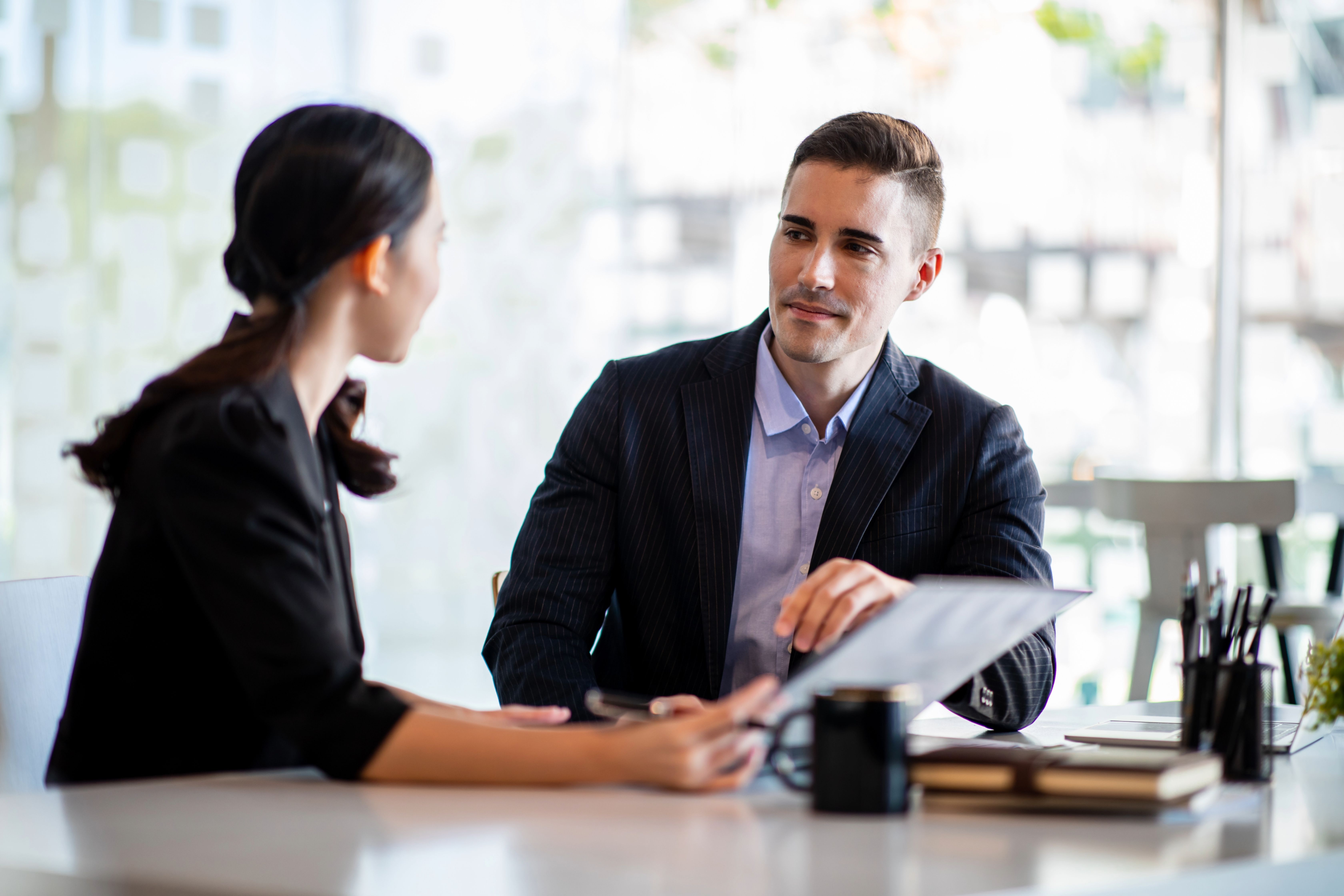 Dealership managers sitting down at a desk having a discussion about 2026 automotive trends
