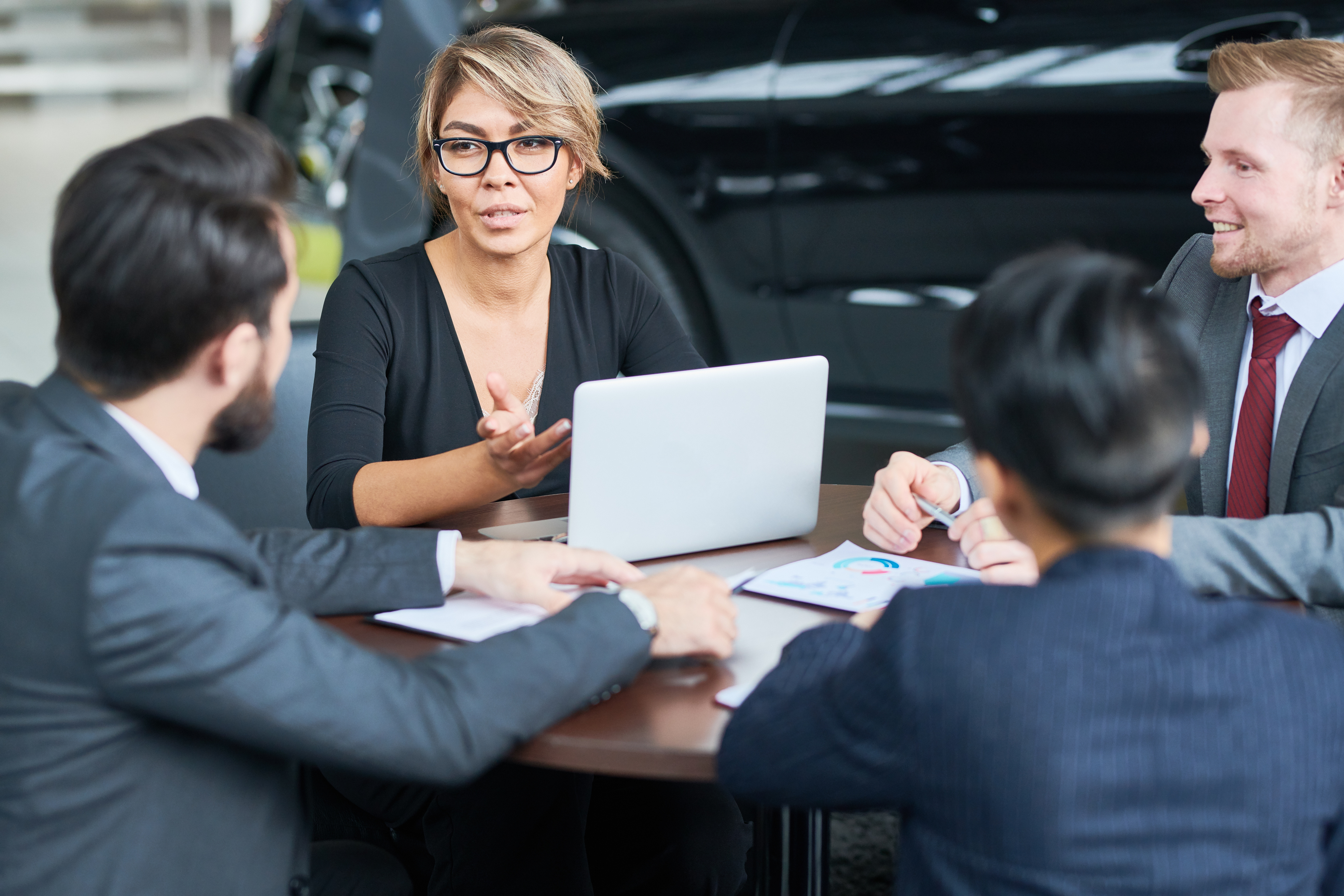 Woman discussing business in a car dealership at desk