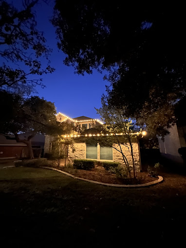 A house in quite a distance that is decorated with Christmas lights.