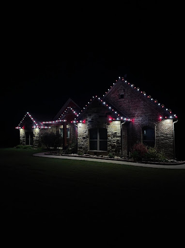 A house in quite a distance that is decorated with Christmas lights.