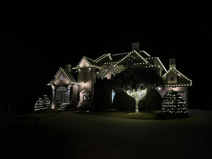 A house in quite a distance that is decorated with Christmas lights.