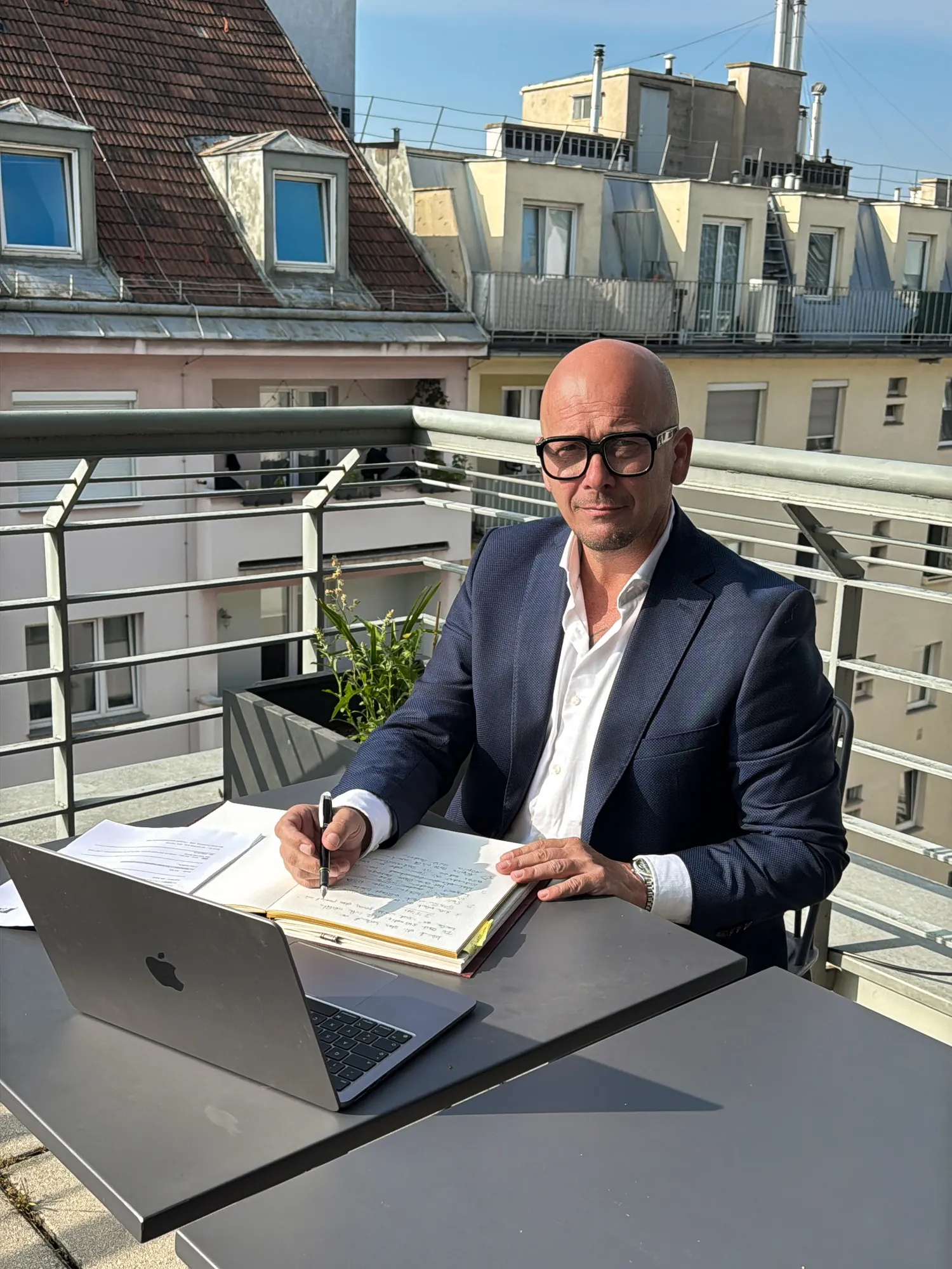 Arnold Freissling arbeitet auf einer Dachterrasse an seinen Notizen