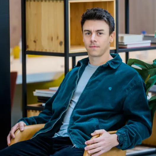 Foto van de Jelle, oprichter van digitale groei in een kantooromgeving al zittend