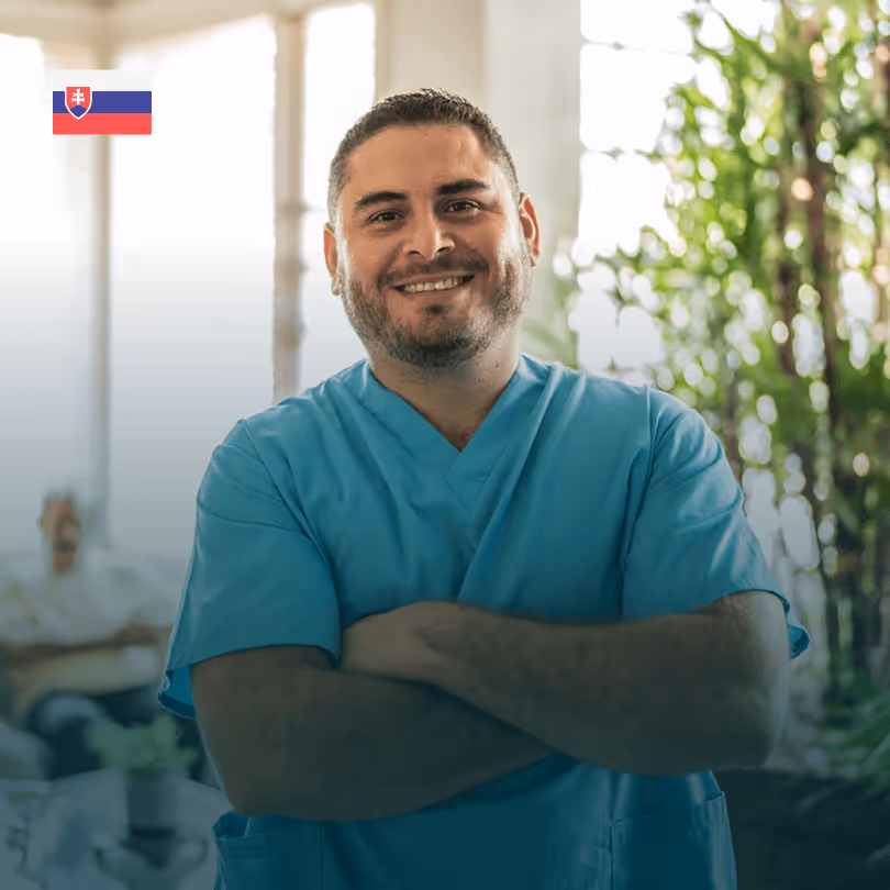 Pflegekraft in blauer Uniform lächelt; slowakische Flagge, Pflanzen im Hintergrund.