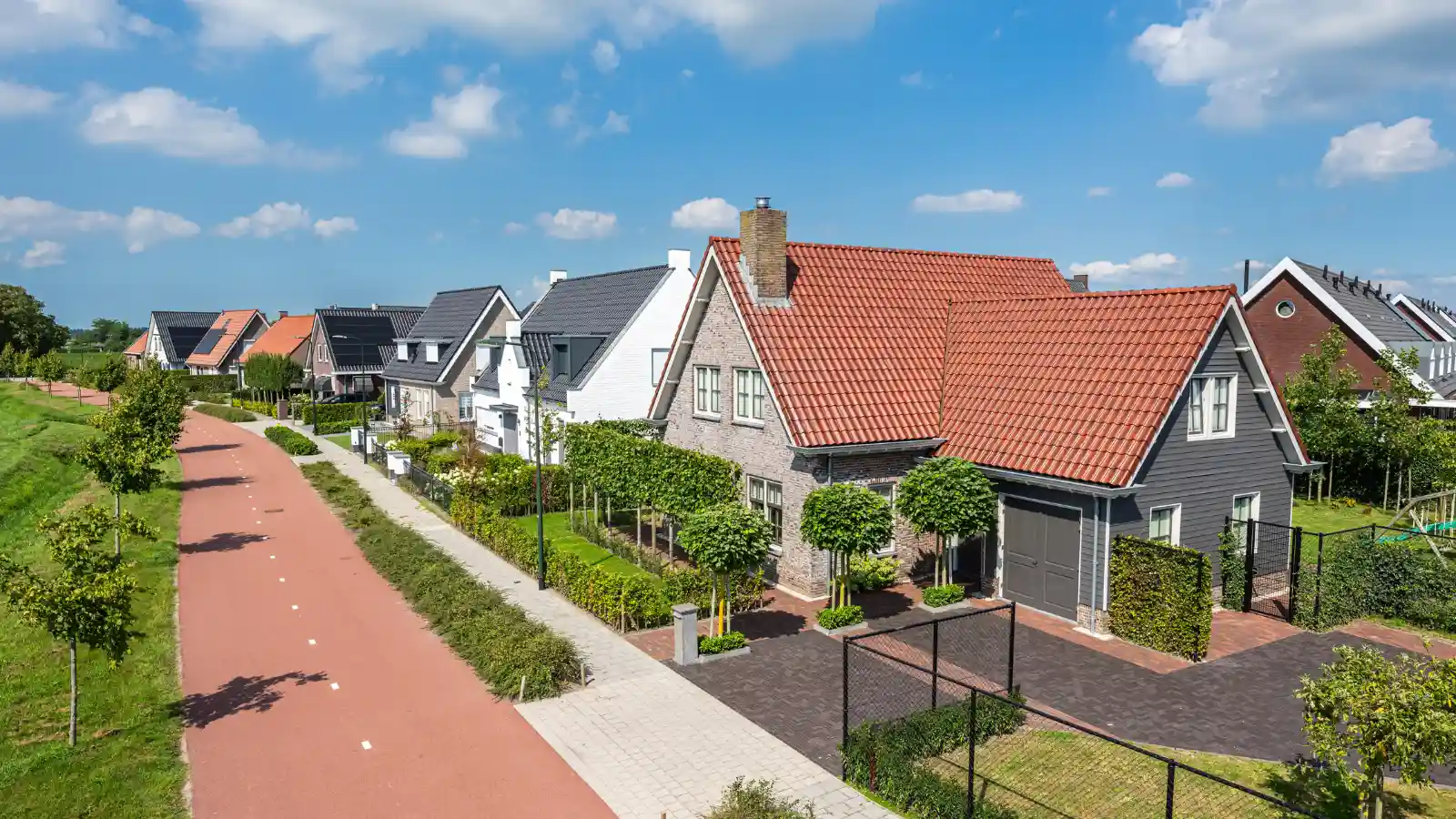 Straat met verschillende vrijstaande woningen een aan fietspad