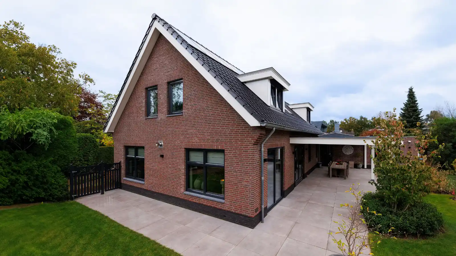Vrijstaande woning met zwarte kozijnen en veranda