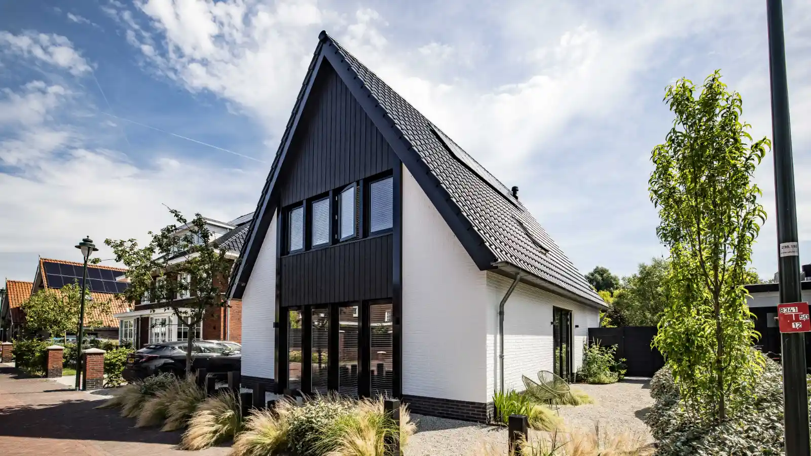Witte moderne gezinswoning met zwart houten gevelbekleding