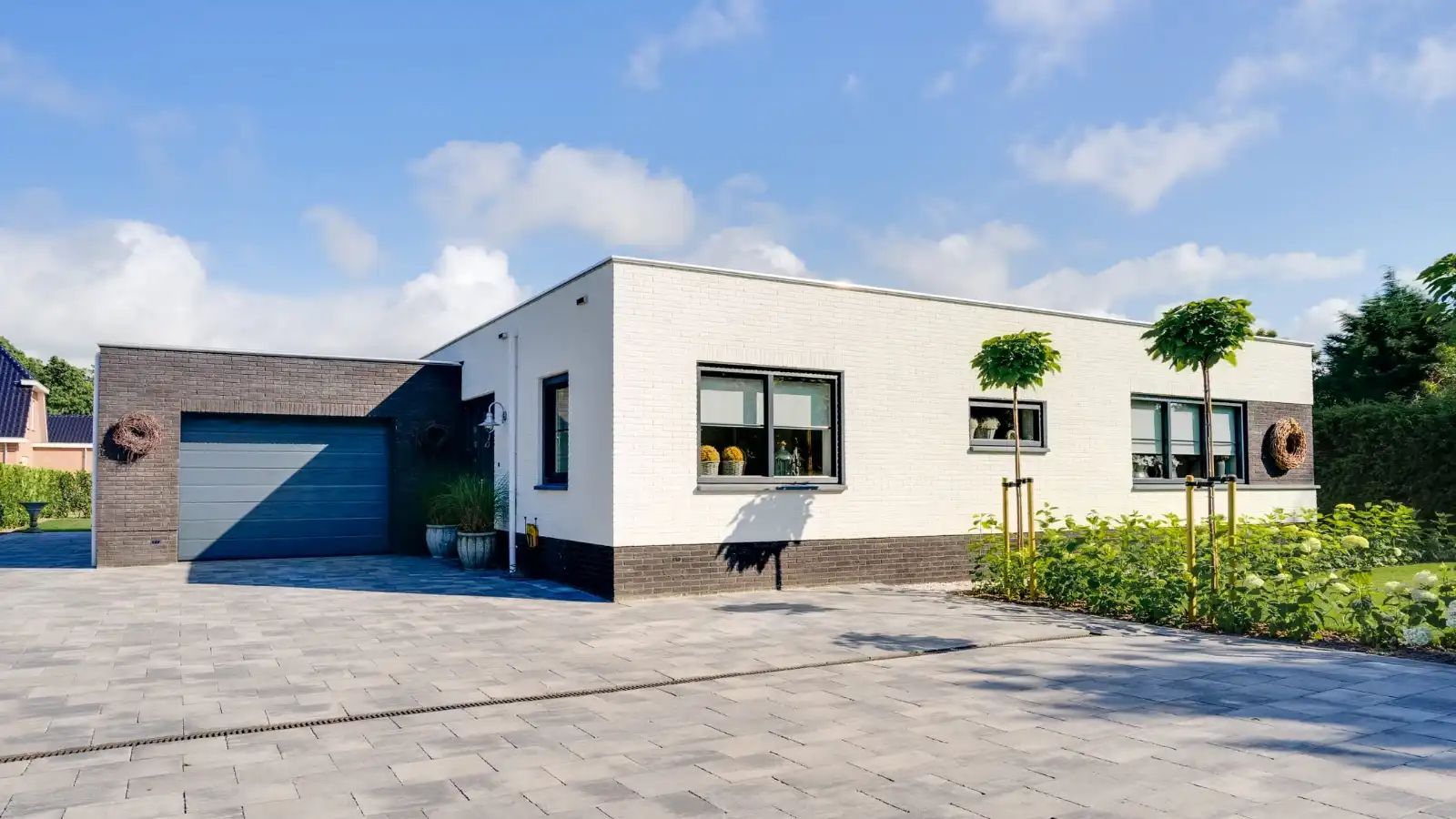 Witte stenen bungalow woning met aangebouwde garage
