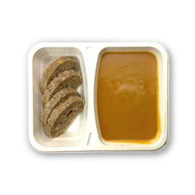 Plastový talíř s čtyřmi plátky vánočního cukroví a porcí oranžové dýňové polévky.