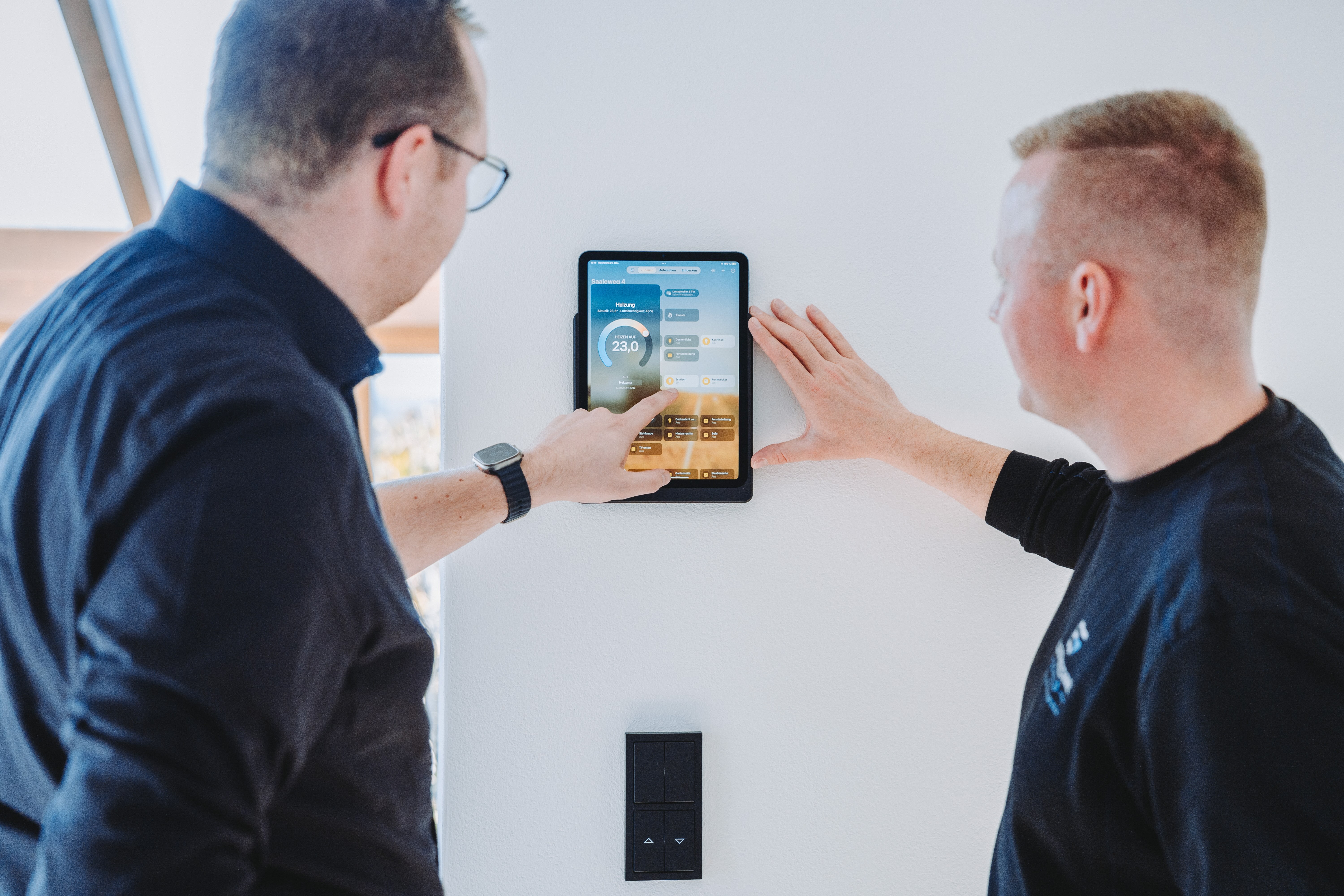 Zwei Personen bedienen Smart-Home-System – Hausautomatisierung durch Elektro Schuld