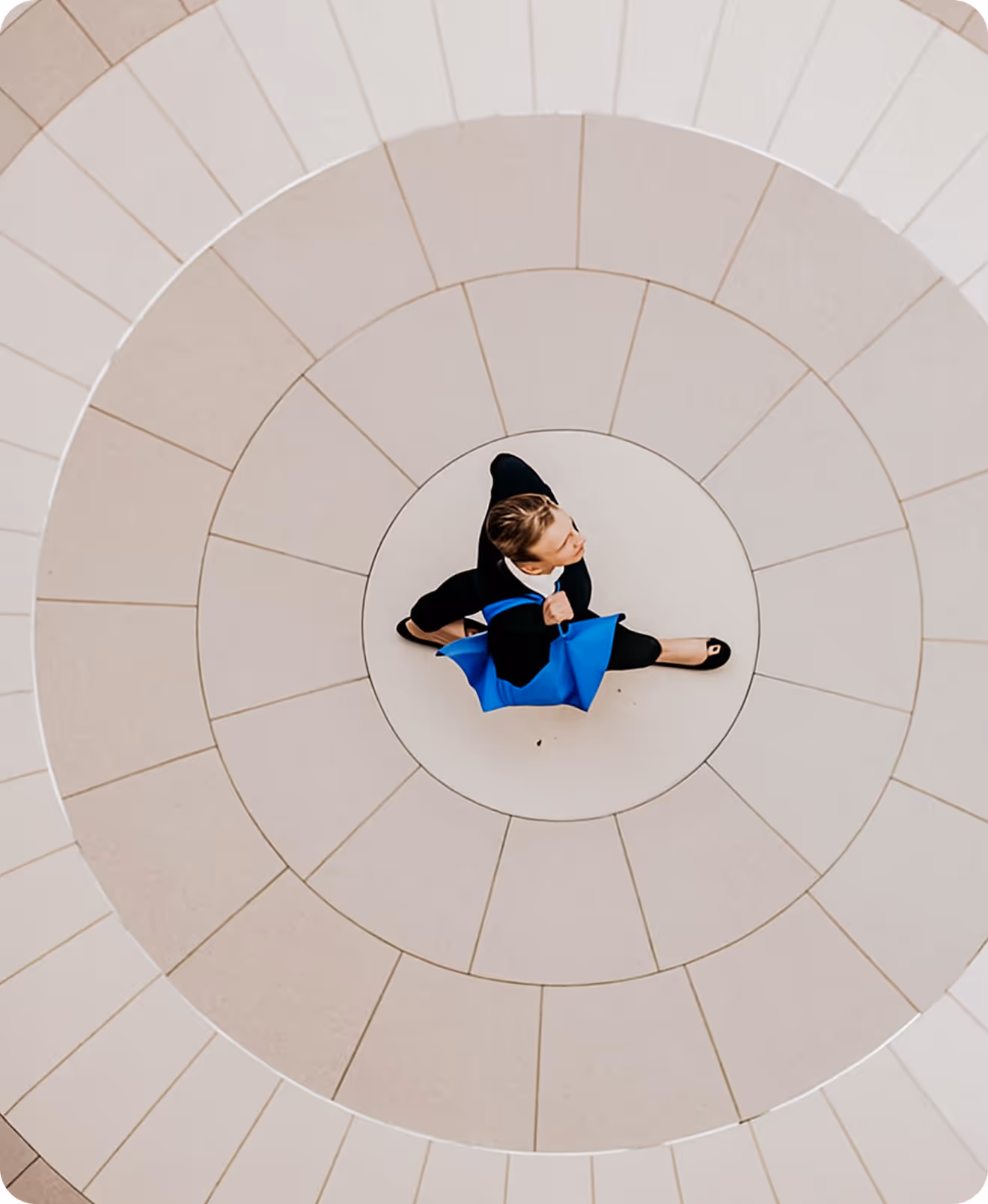 A young boy sitting on a white circular structure.