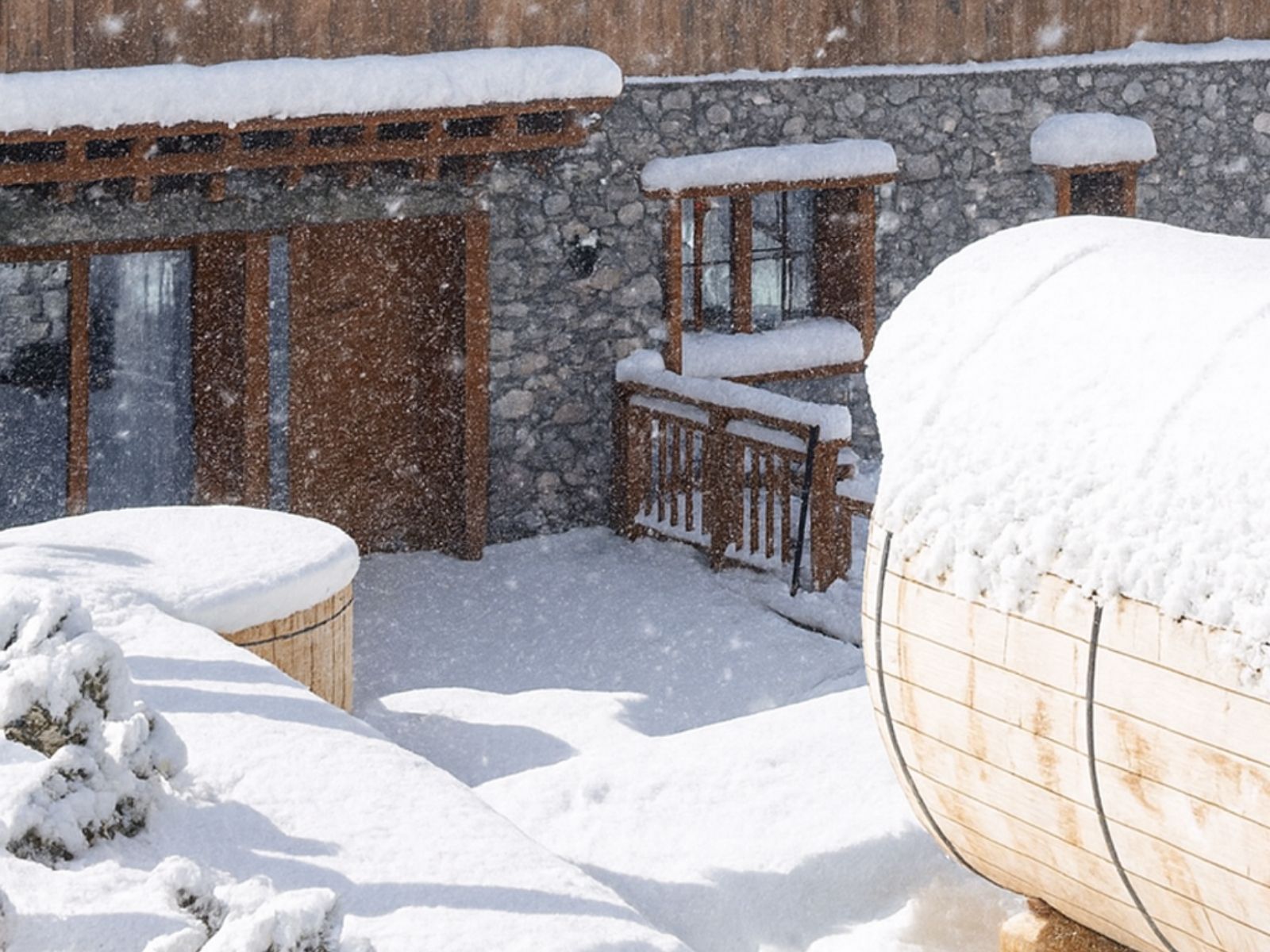 Espace bien-être en hiver avec spa et bain nordique extérieur dans un chalet haut de gamme des 3 Vallées