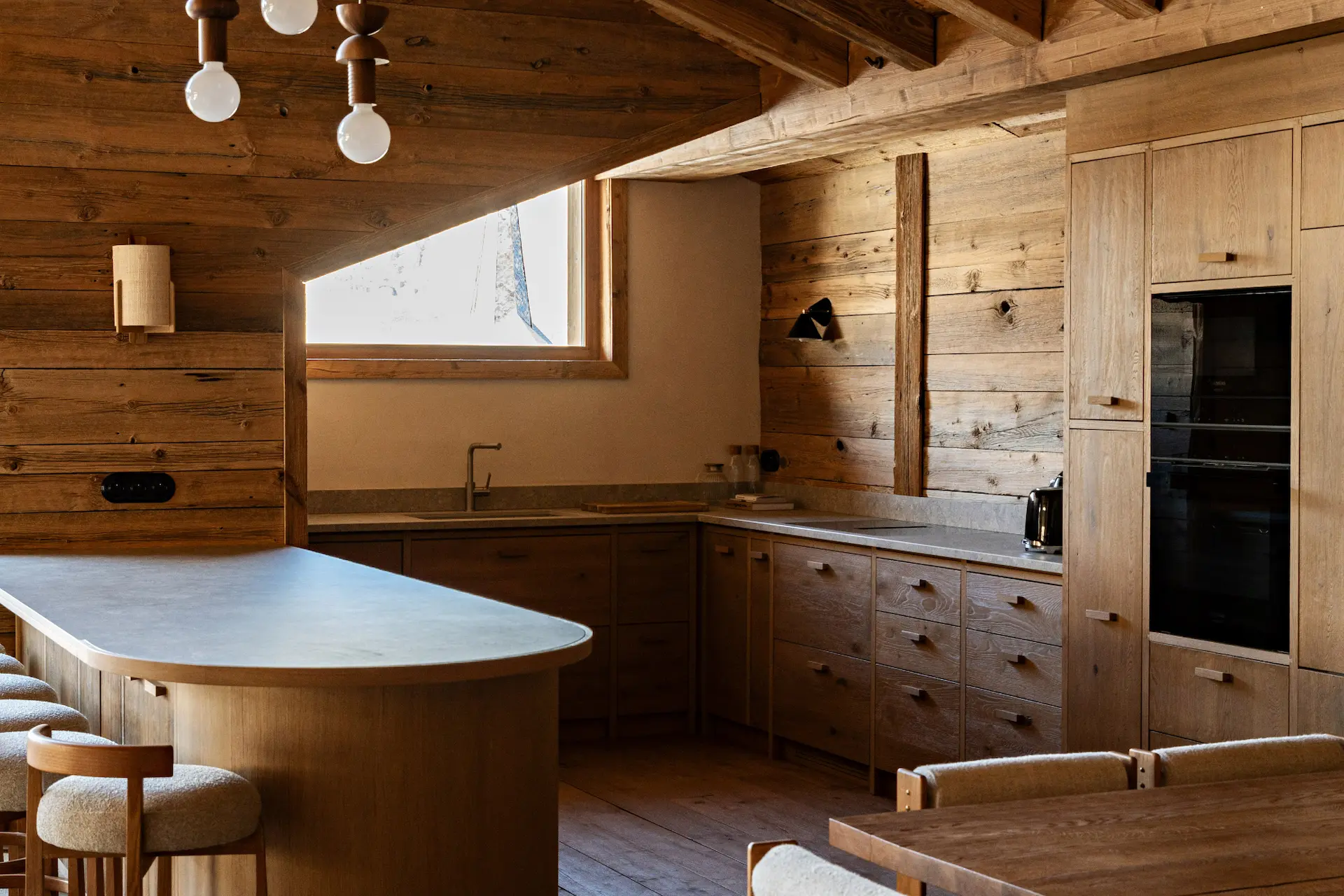 Cuisine ouverte avec coin repas dans un chalet haut de gamme au pied des pistes de ski