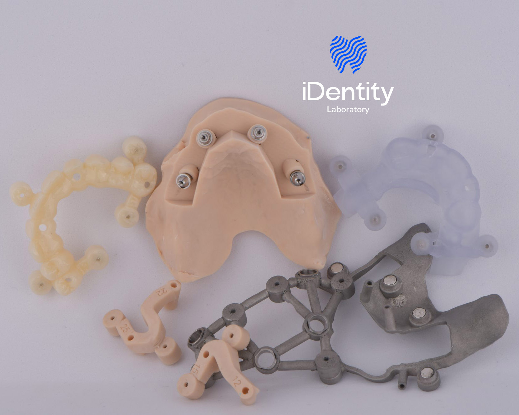Various dental surgical guides and implant components arranged on a white surface with the iDentity Laboratory logo above.
