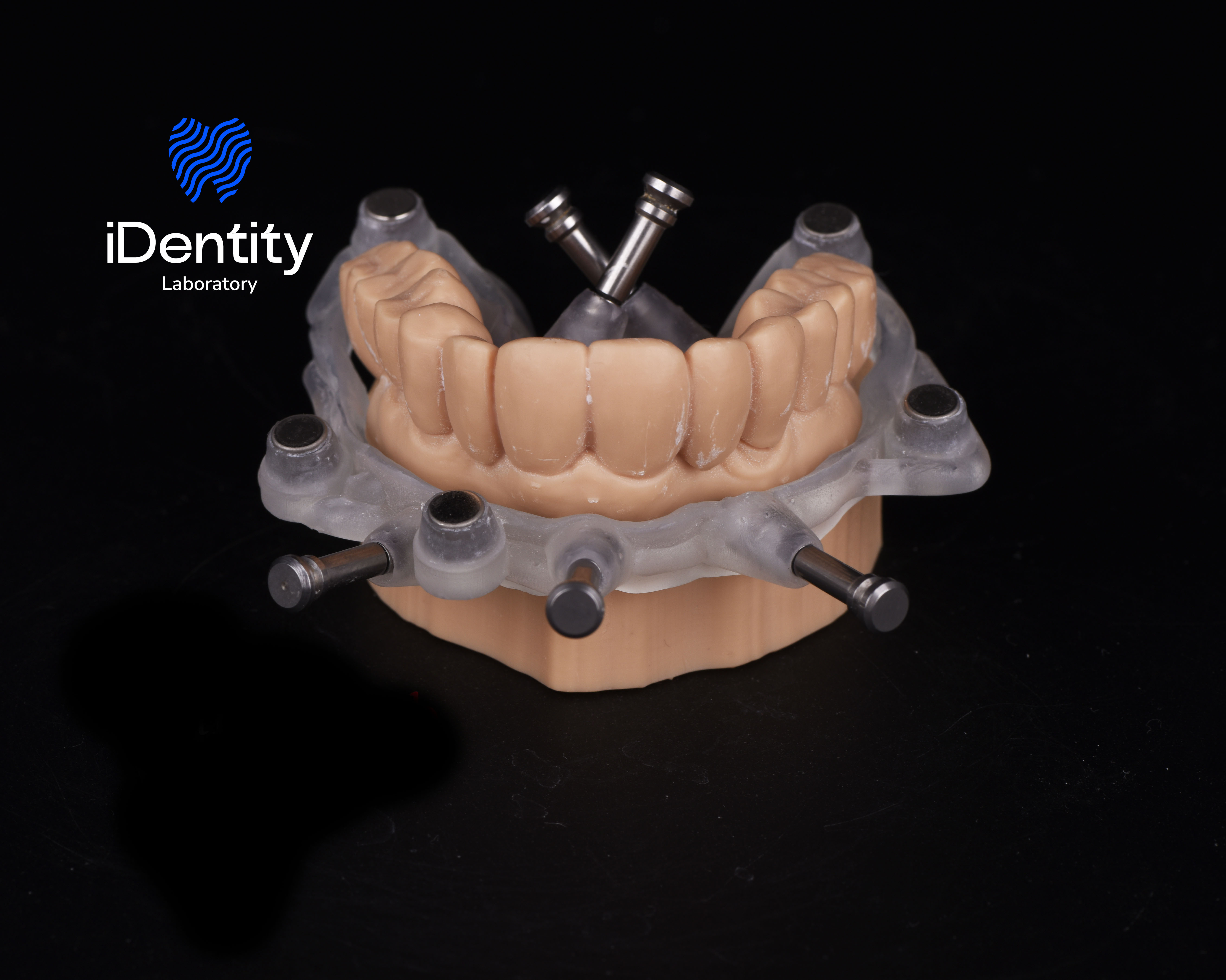 Dental implant surgical guide fitted on a model of upper jaw with prosthetic teeth.