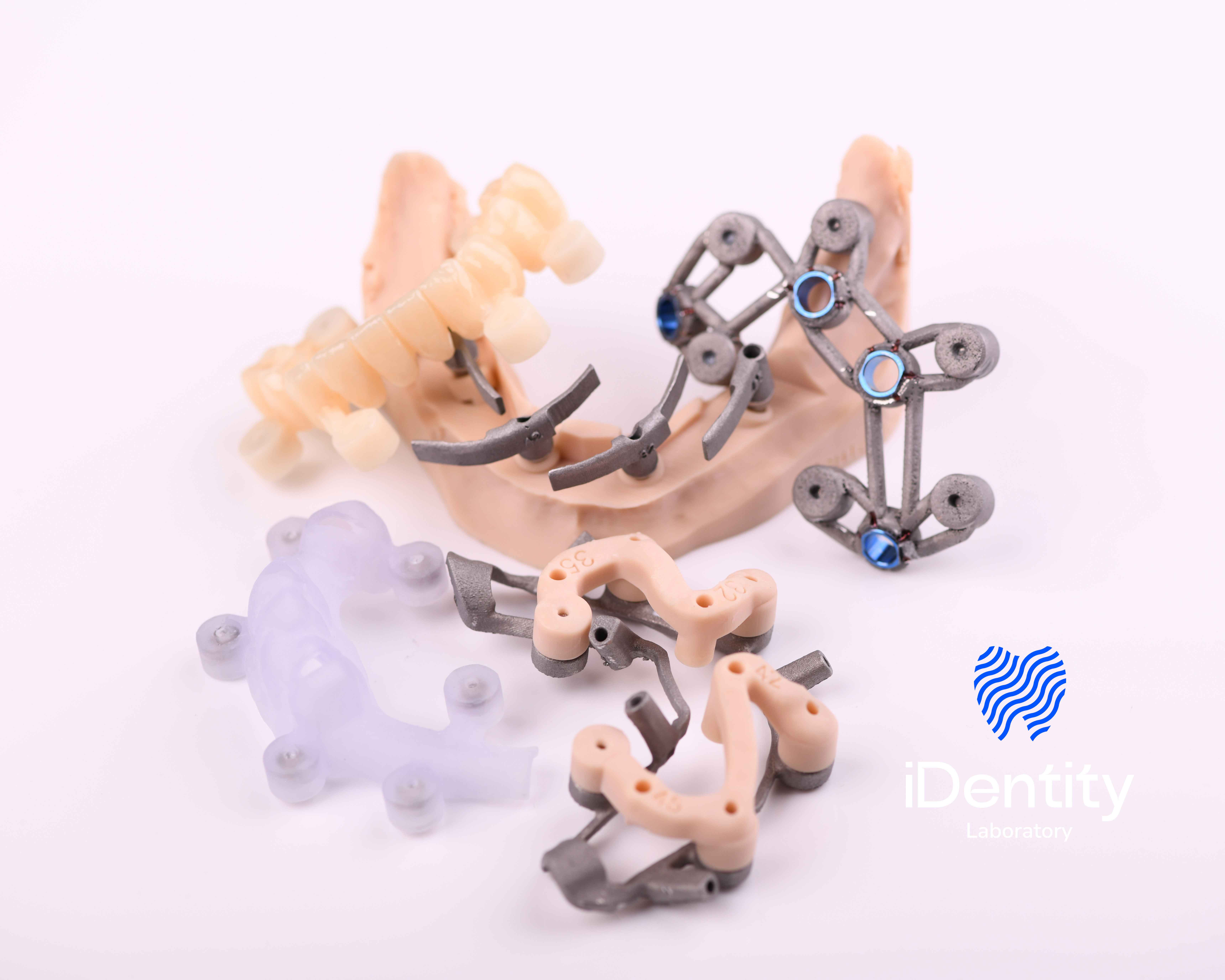 Collection of dental models and surgical guides with a logo reading iDentity Laboratory on a white background.