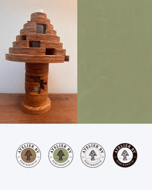Holzkunstobjekt mit mehreren runden, gestapelten Schichten auf einem Holztisch neben vier Varianten des Logos 'Atelier by Romi & Martin'.