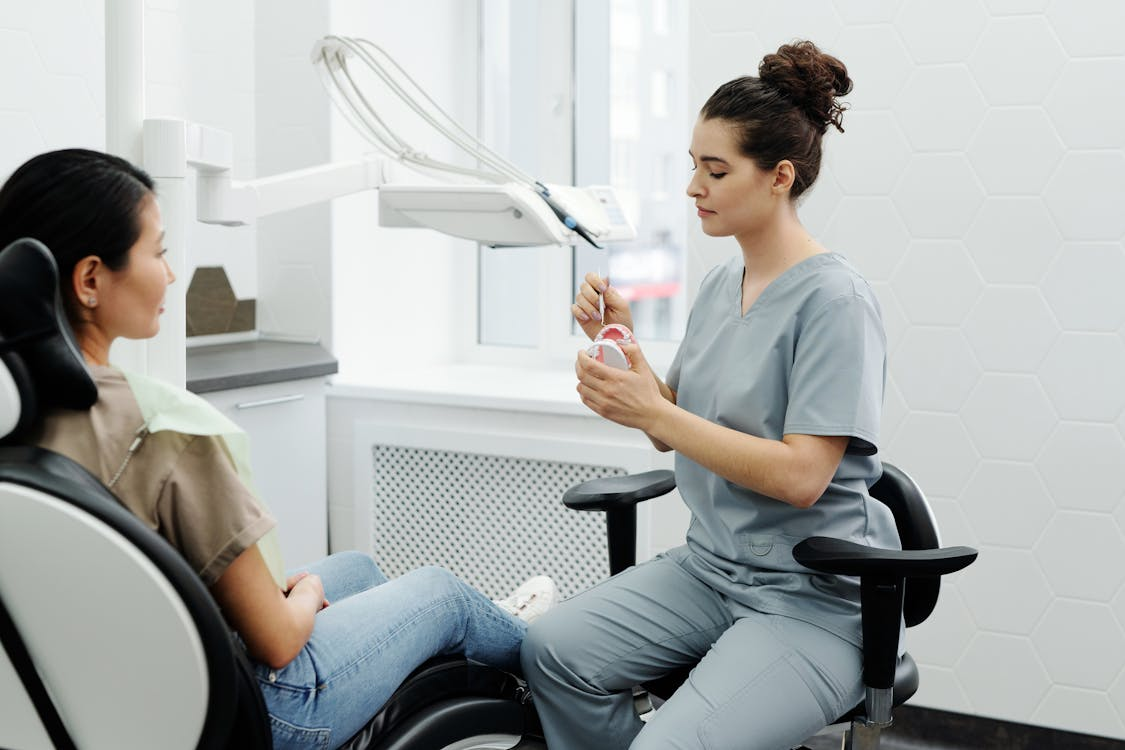 A medical assistant is consulting and showing a patient what to do