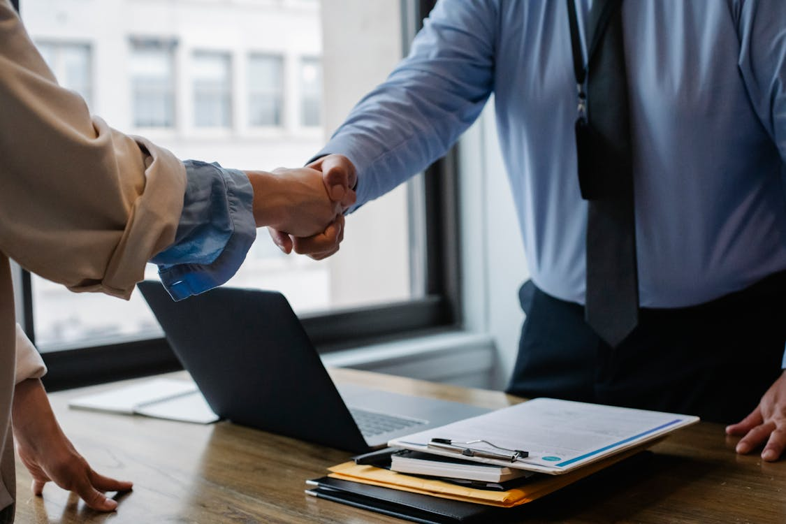 wo persons are making handshake in a professional environment symbolizing medical assistant getting hired