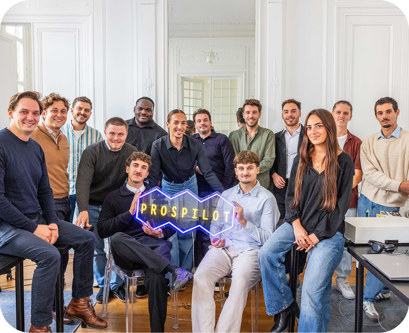 L'équipe de Prospilot avec certaines personnes debout et d'autres assises, tenant le logo de Prospilot dans les mains