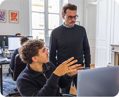 deux personnes de chez prospilot discutant devant un ordinateur