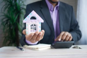 guy holding small model house