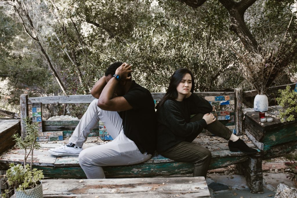 couple sitting in park not talking Signs Of Infidelity: What Are the Common Signs That A Partner May Be Cheating?