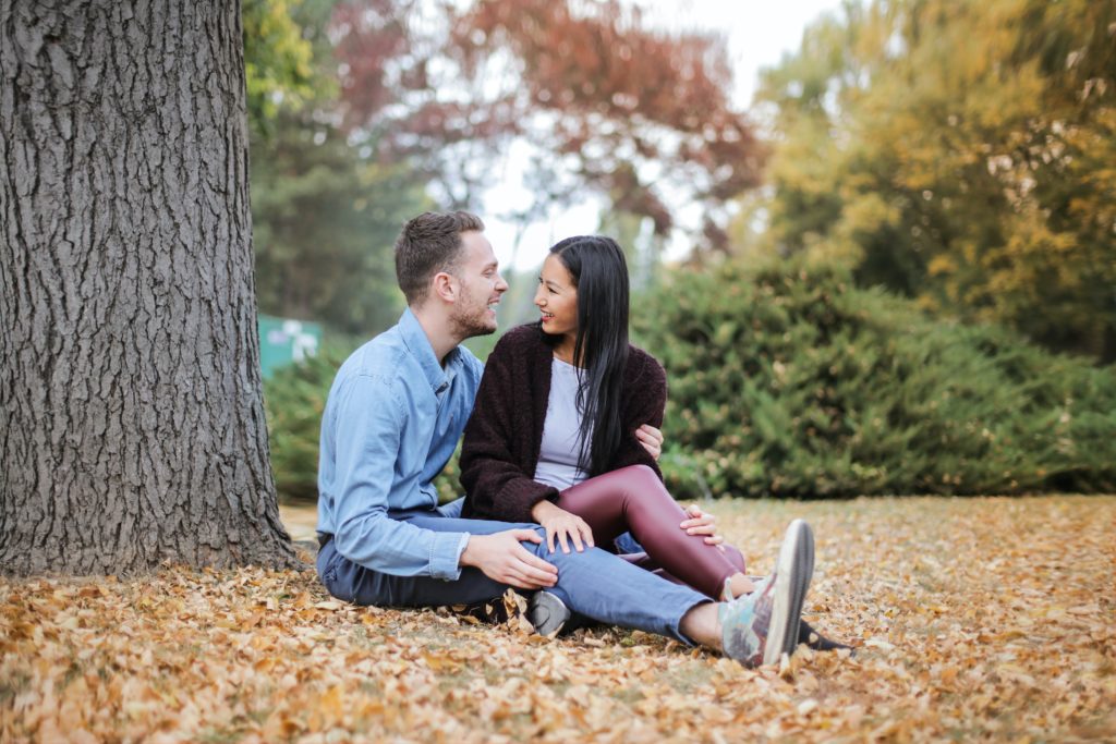 couple sitting in the park talking Discussing Future Possibilities In A Prenup With Your Partner