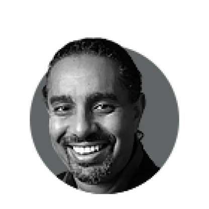 Black and white headshot of a smiling man with a beard and dreadlocks.