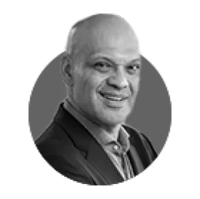 Black and white headshot of a smiling bald man.