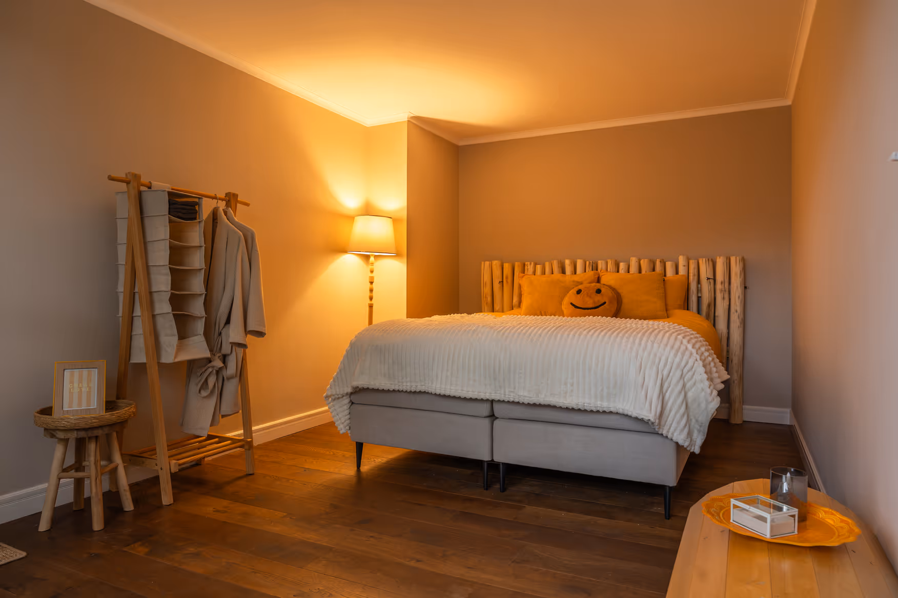 Ruime kamer met houten vloer en boxspringbed bij Fiks Bed & Boerderij