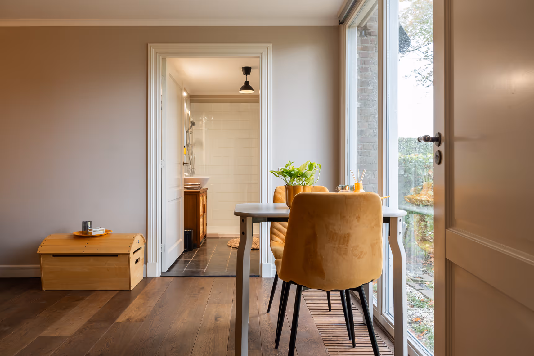 Kamer met eettafel, uitzicht op tuin en toegang tot badkamer