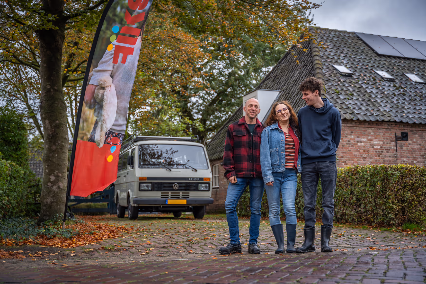 Gezin staat voor Fiks Bed en Boerderij met een oldtimer camper