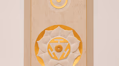 Holzplatte mit geschnitztem und golden bemaltem mandalaähnlichem Muster.