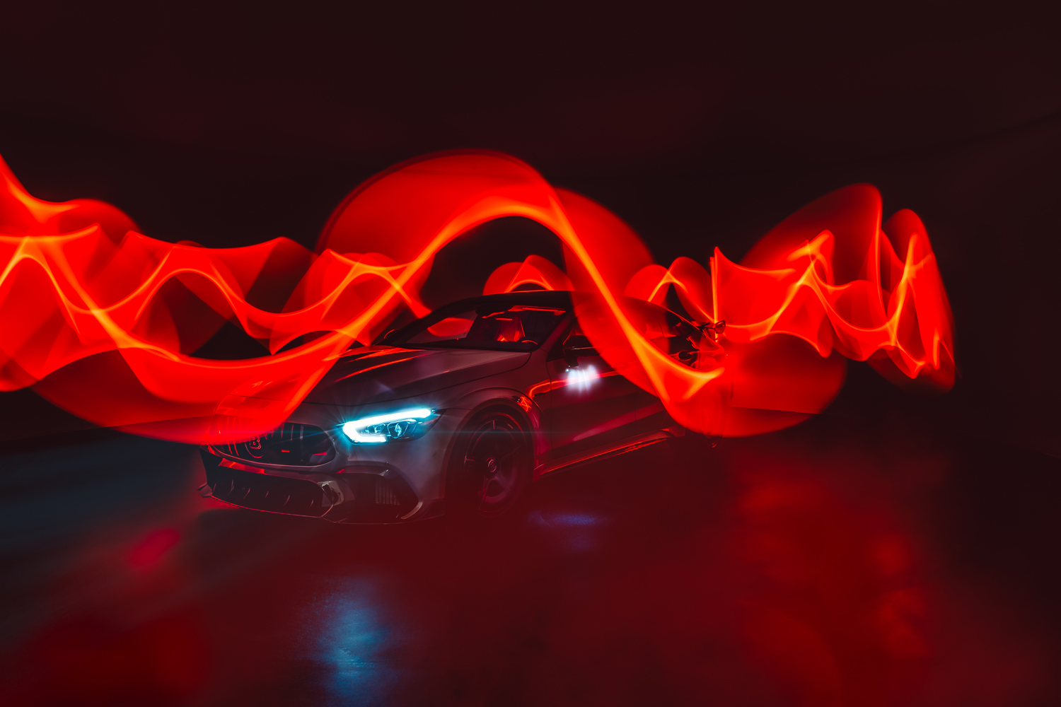 Silver sports car with bright headlights surrounded by swirling red light trails in a dark setting.
