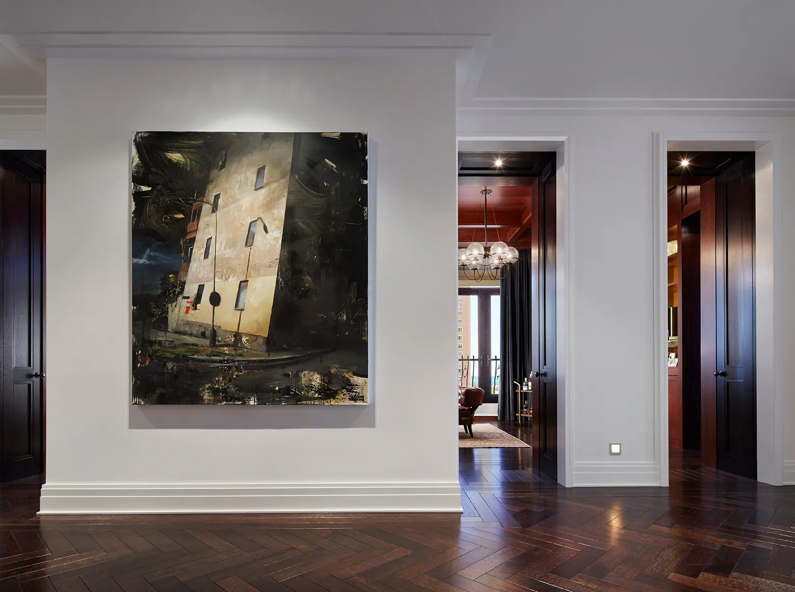 Modern hallway with dark wooden floor, two dark doors, and a large abstract building painting on the wall.