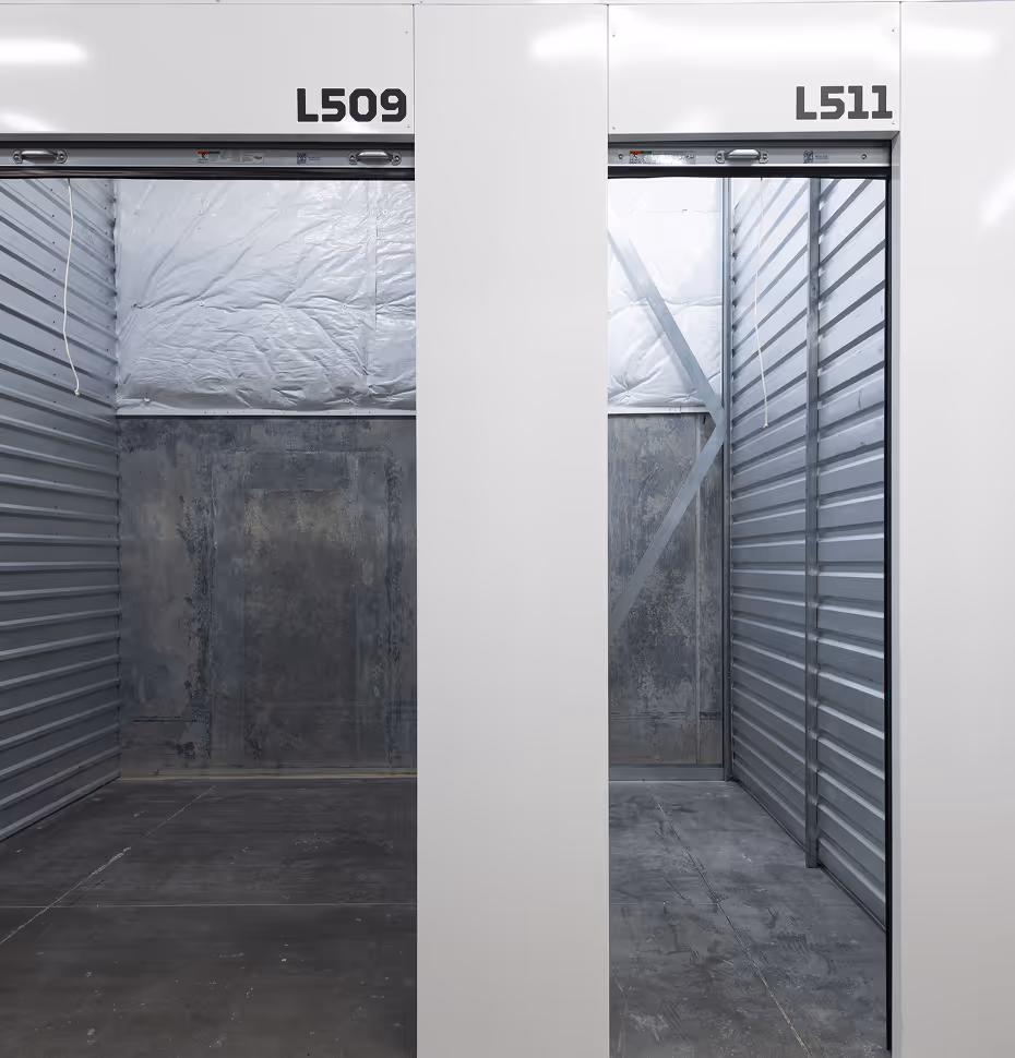 Empty adjacent storage units L509 and L511 with open metal roll-up doors inside a storage facility.